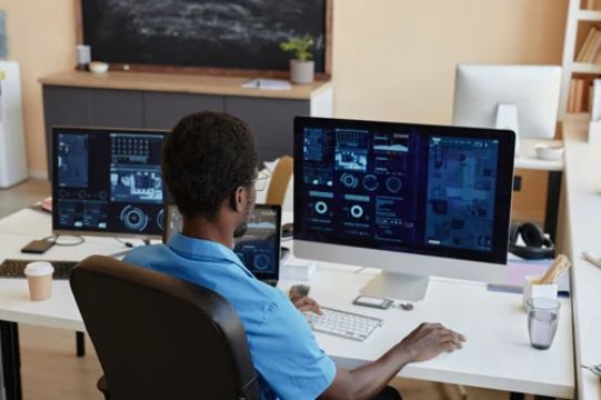Rear view of young African American businessman sitting by workplace